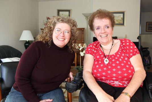 Two smiling women in a living room