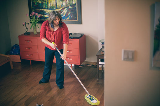 A woman mopping a hardwood floor