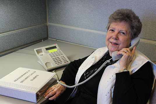 An older woman talking on a telephone